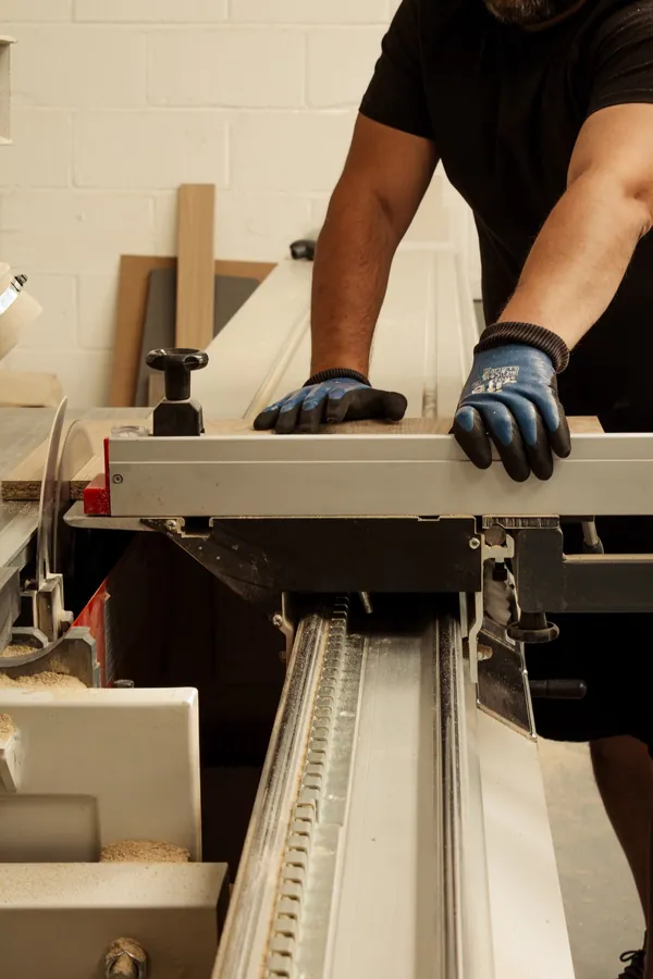 Craftsman cutting an oak board to size on the panel saw at Superio Furniture