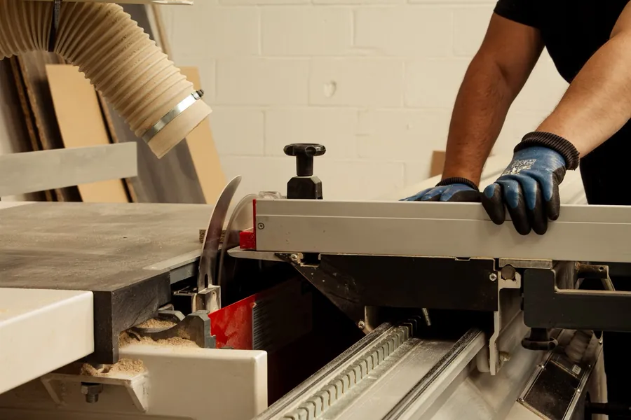 Guiding a panel through the sliding table saw